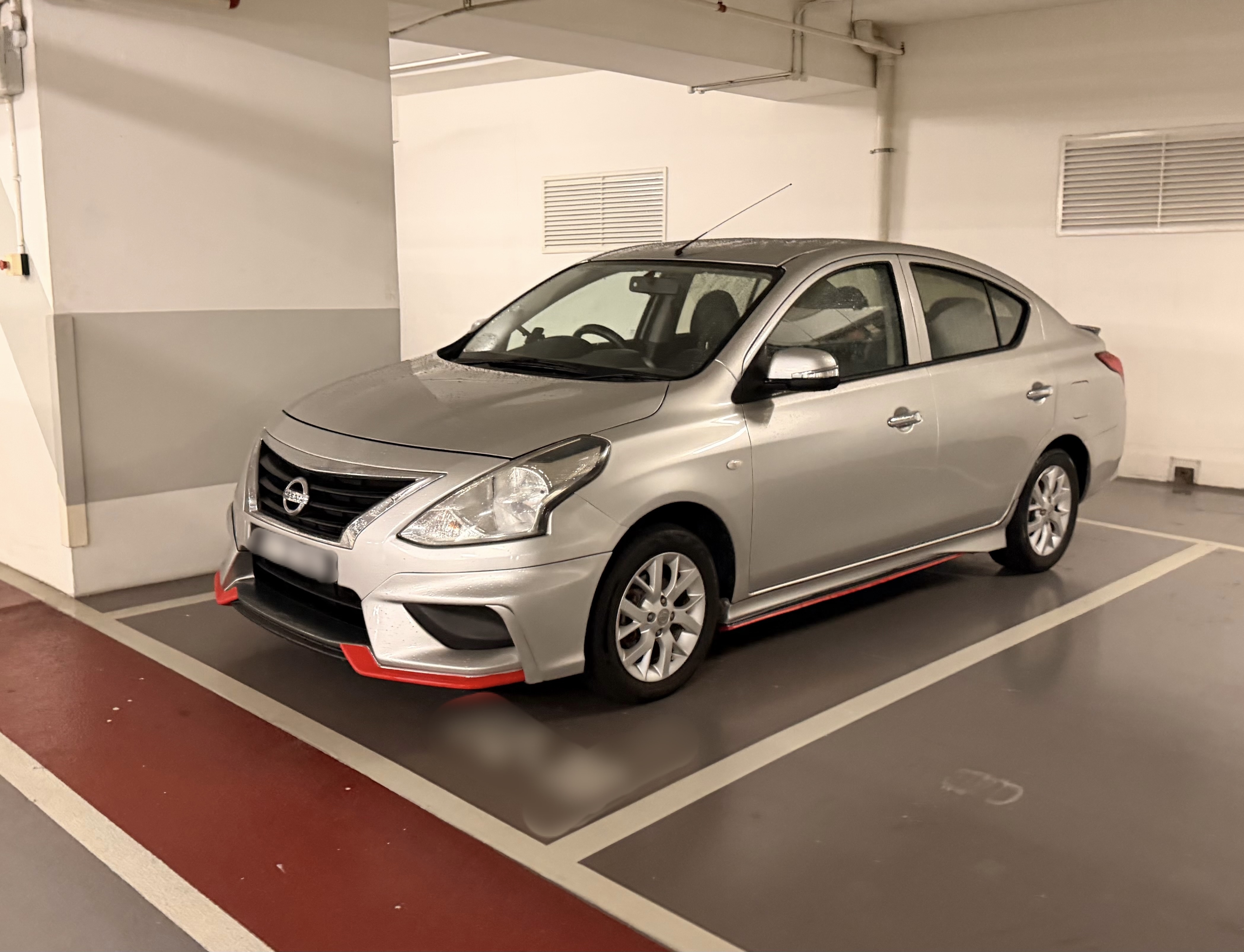 駐車場に停まっているシルバーのセダンタイプの車。